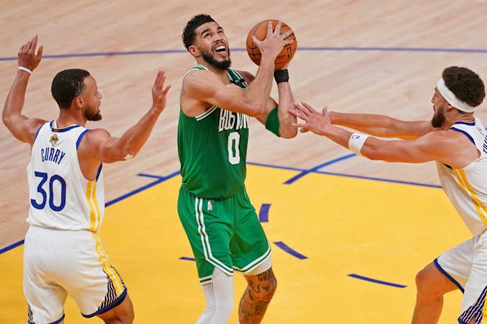Jayson Tatum is defended by Stephen Curry and Klay Thompson.